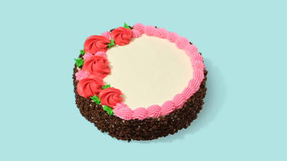 Cake decorated with frosting roses on a white surface with a blue background.