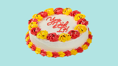 White cake with red and yellow frosting. Words on the cake read "You got your wish! Congratulations!"